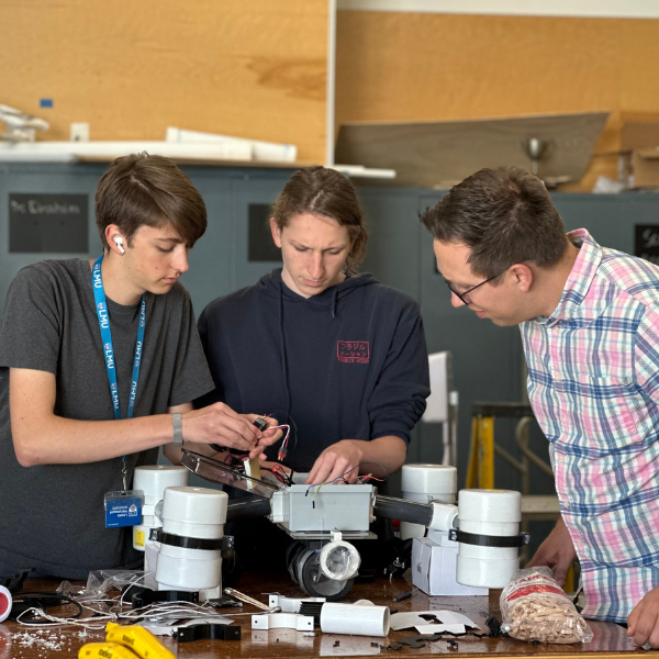 LMU faculty member works with two pre-college students on an engineering project.